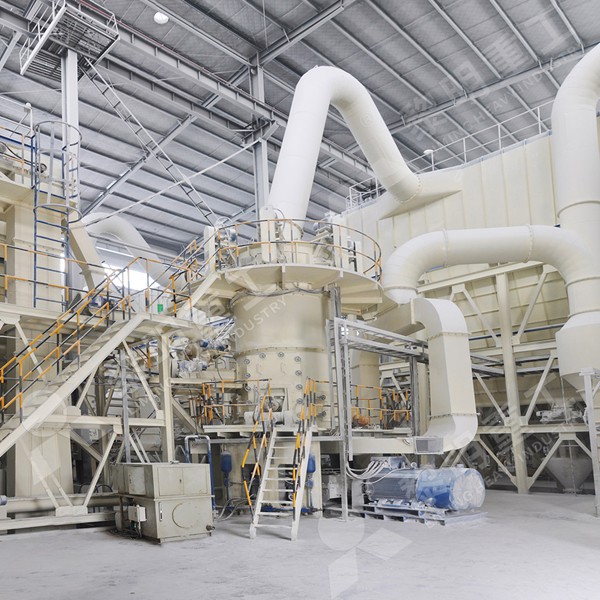 A large industrial Raymond grinding mill installation in a limestone processing plant, showing the main mill body, classifier, and ductwork.